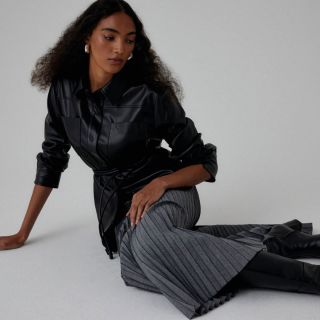 Elegantní minimalismus v černé. Kožený vzhled, čisté linie a výrazná plisovaná sukně tvoří kombinaci, která je stejně...